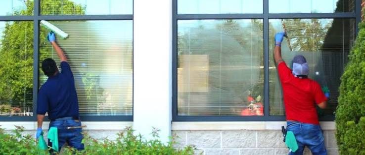 Two commercial window cleaners washing storefront glass for a Lathrop, CA business
